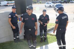 Gruppo di volontari dell’Associazione Nazionale Carabinieri in uniforme, in piedi all’esterno durante un evento.