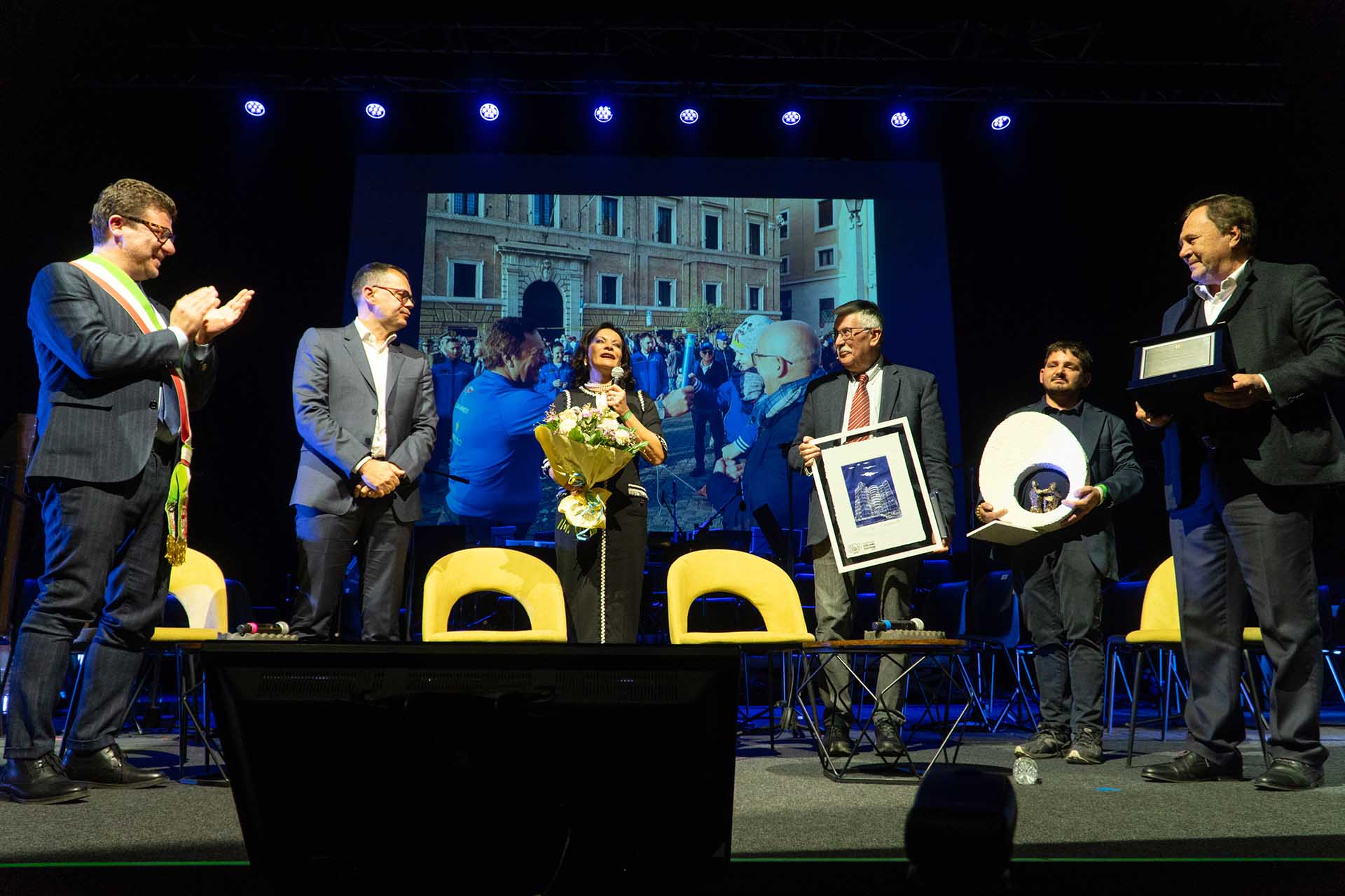 Stefania Fochesato con un mazzo di fiori in mano che parla al pubblico