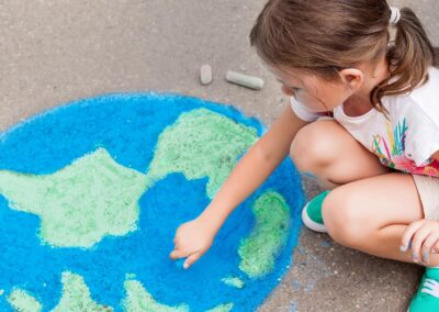 bambina che gioca per terra disegnando un globo