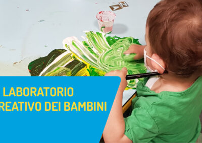 Bambino che disegna con i colori sul tavolo e la scritta il laboratorio creativo dei bambini