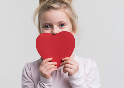 bambina con un cuore di carta in mano